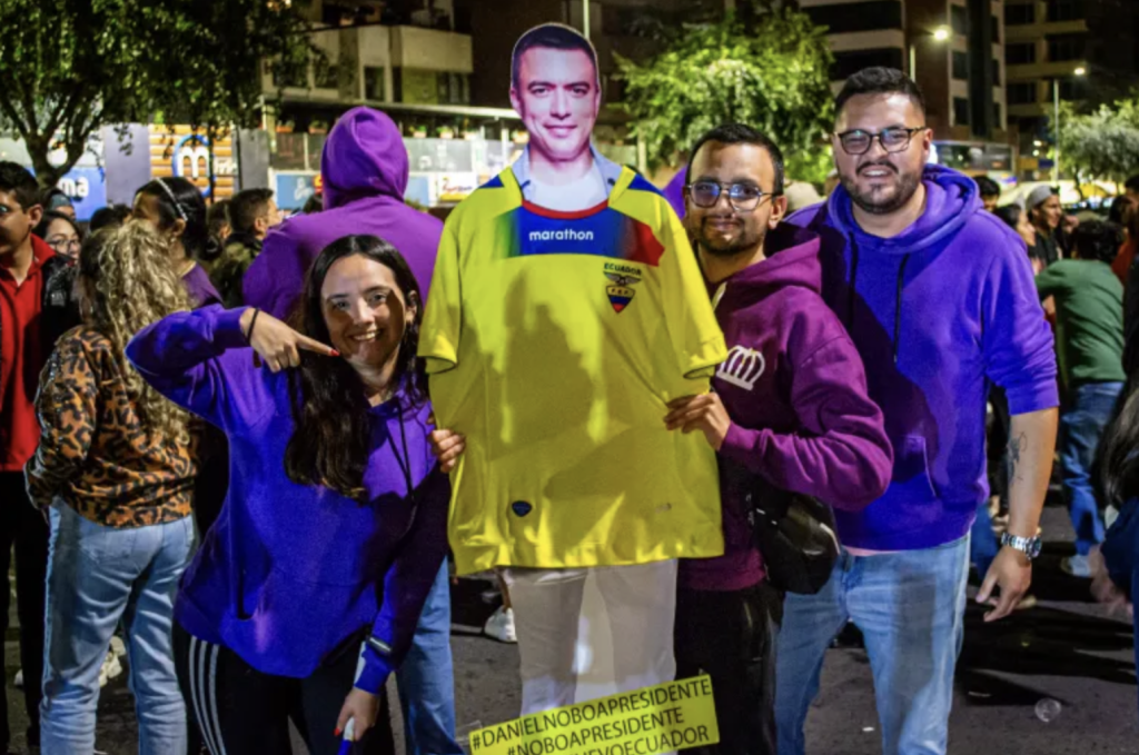 Maria Paz, left, celebrates with her life-sized cardboard cut-out of candidate Daniel Noboa on October 15 in Quito, Ecuador [Michele Bertelli/Al Jazeera]